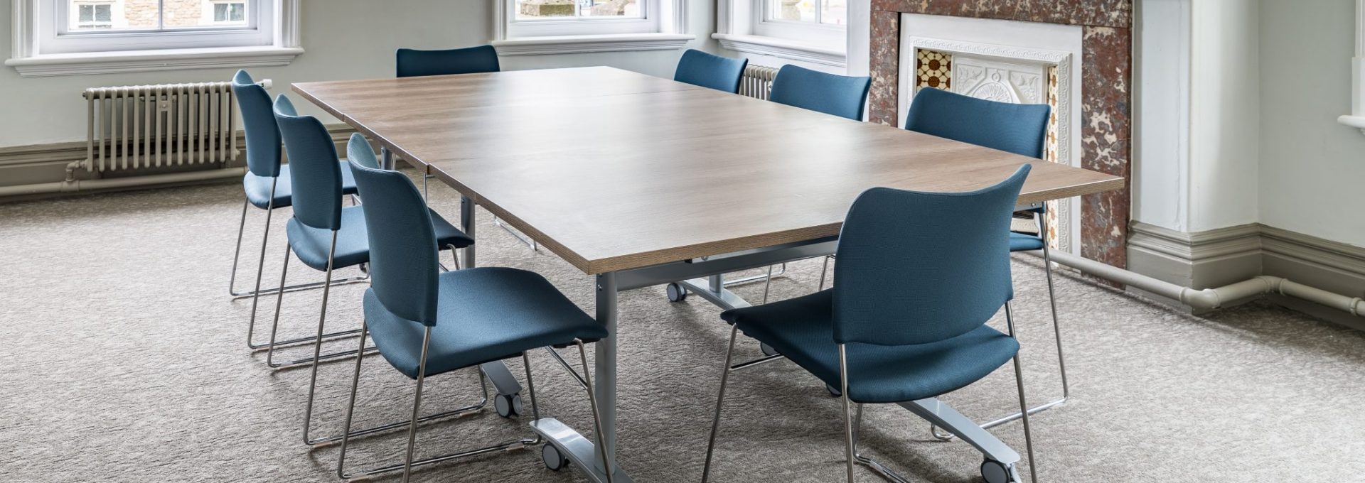 Photo of a large table with chairs around it at Frome Town Hall's meeting room.