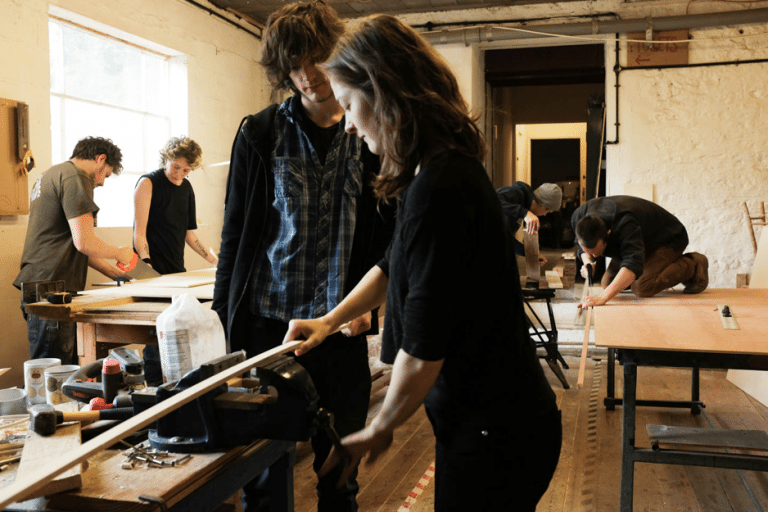 Two people in a wood workshop.