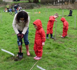 photo of a mother and children planting trees