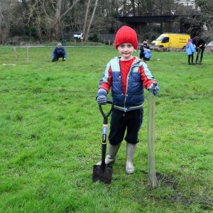 Photo of child holding a spade to plant a tree