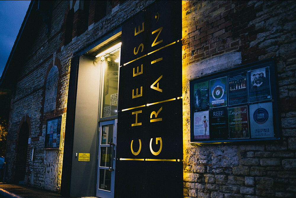 A lit up sign outside the Cheese and Grain venue