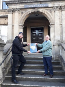 Deputy Mayor Andy Wrintmore receiving an award fromActive and In Touch's Dougie Brown outside Frome Town Hall