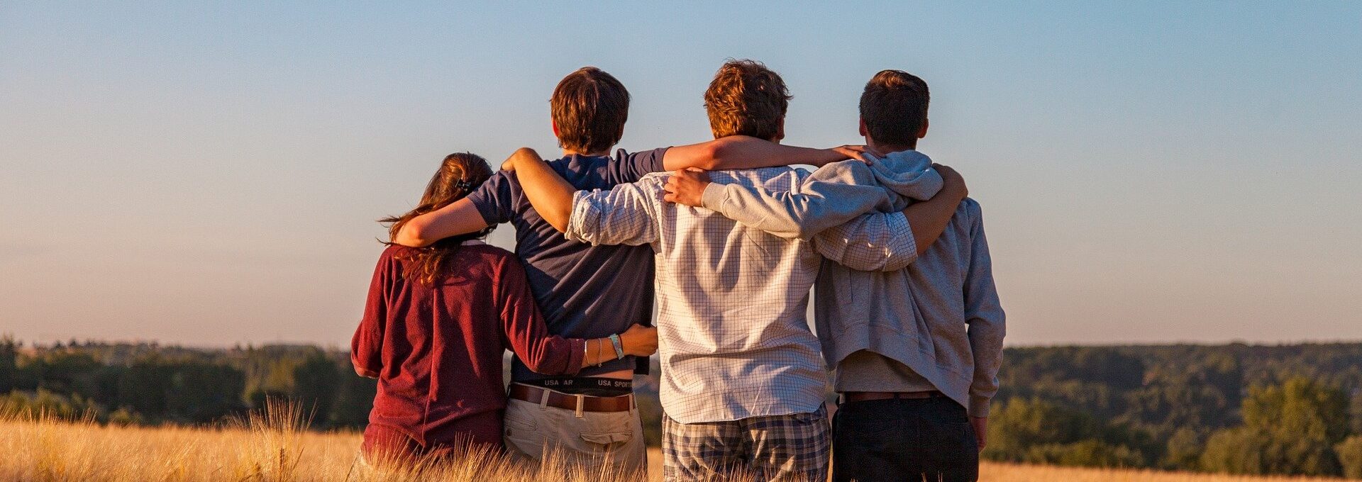 People in field with arms around each other