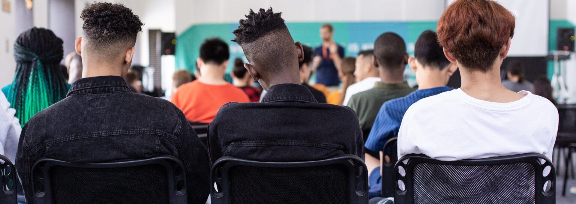 Students in hall listening to teacher