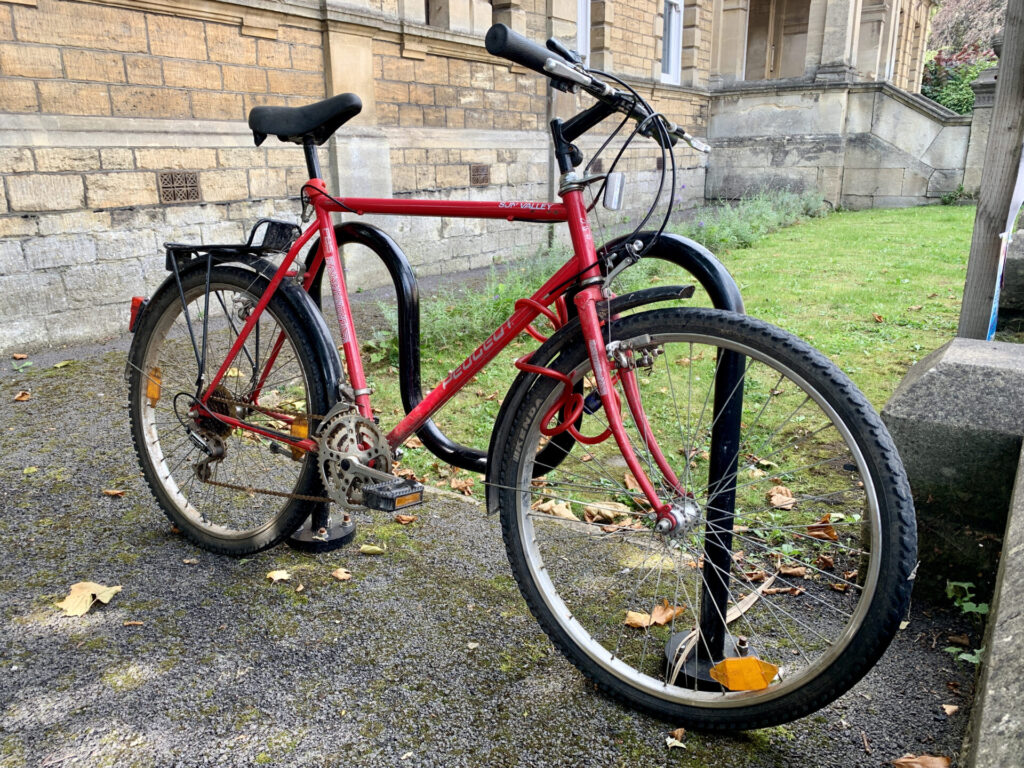 Red bicycle in bicycle rack outside Frome Town Hall