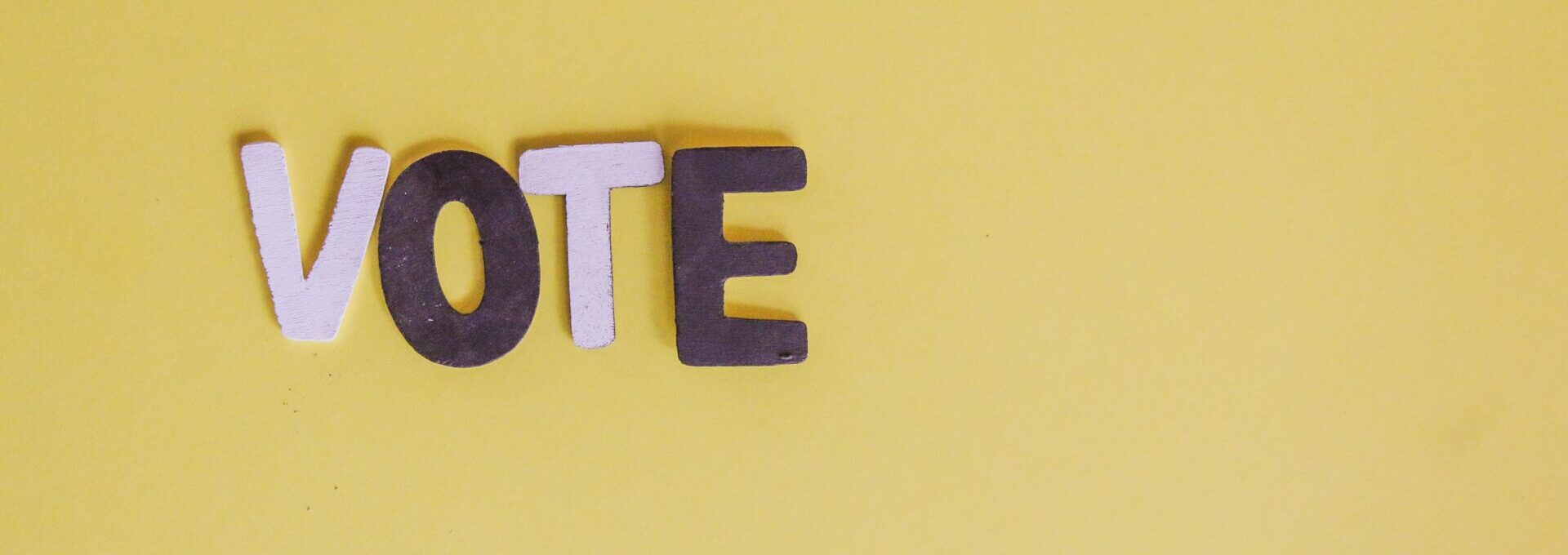 Letters that spell vote on yellow background