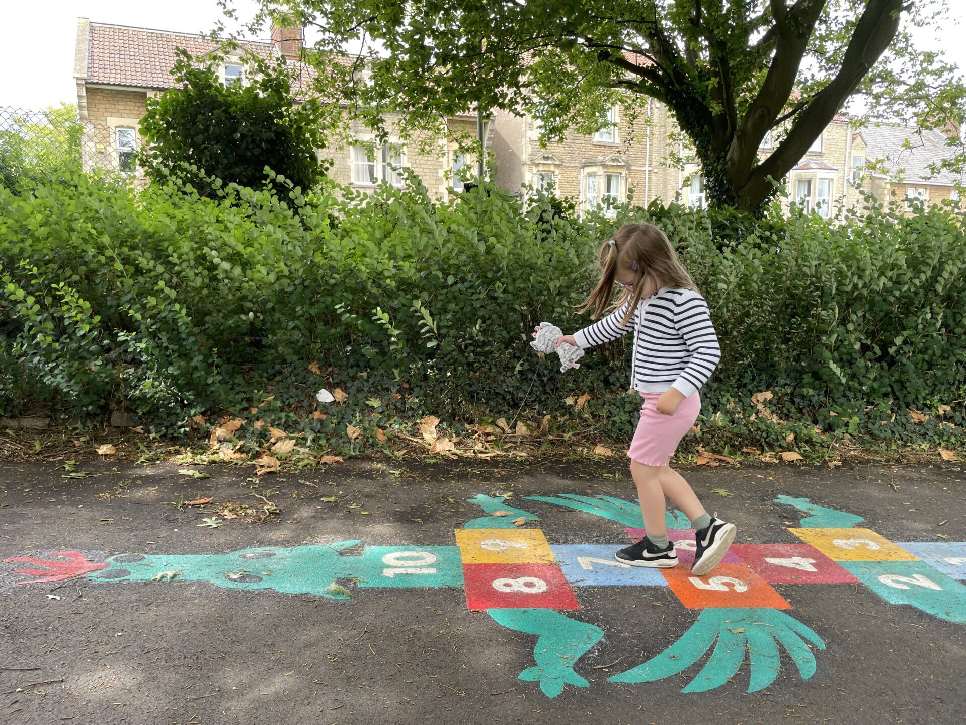 A girl plays on painted dragon hopscotch
