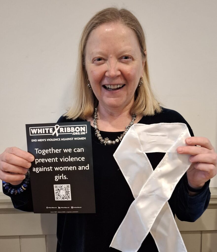 Cllr Anne Hills holding a giant White Ribbon